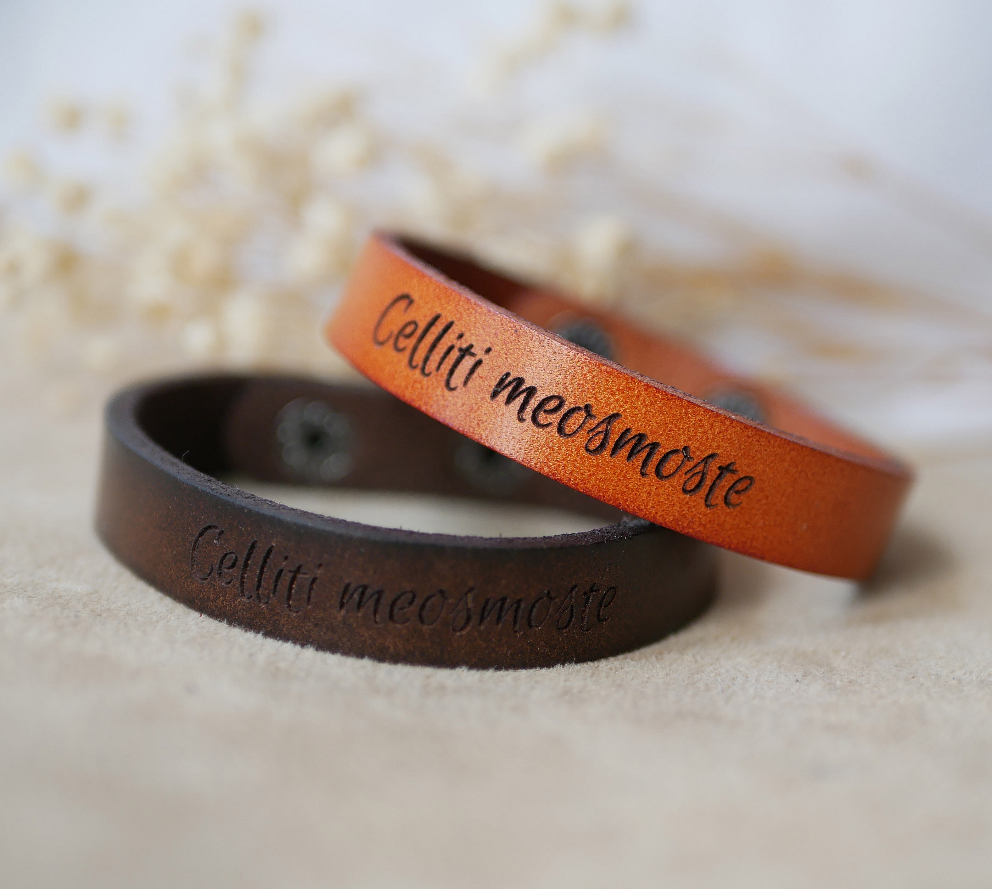 Bracelets mixtes en cuir gravé avec boutons pression.