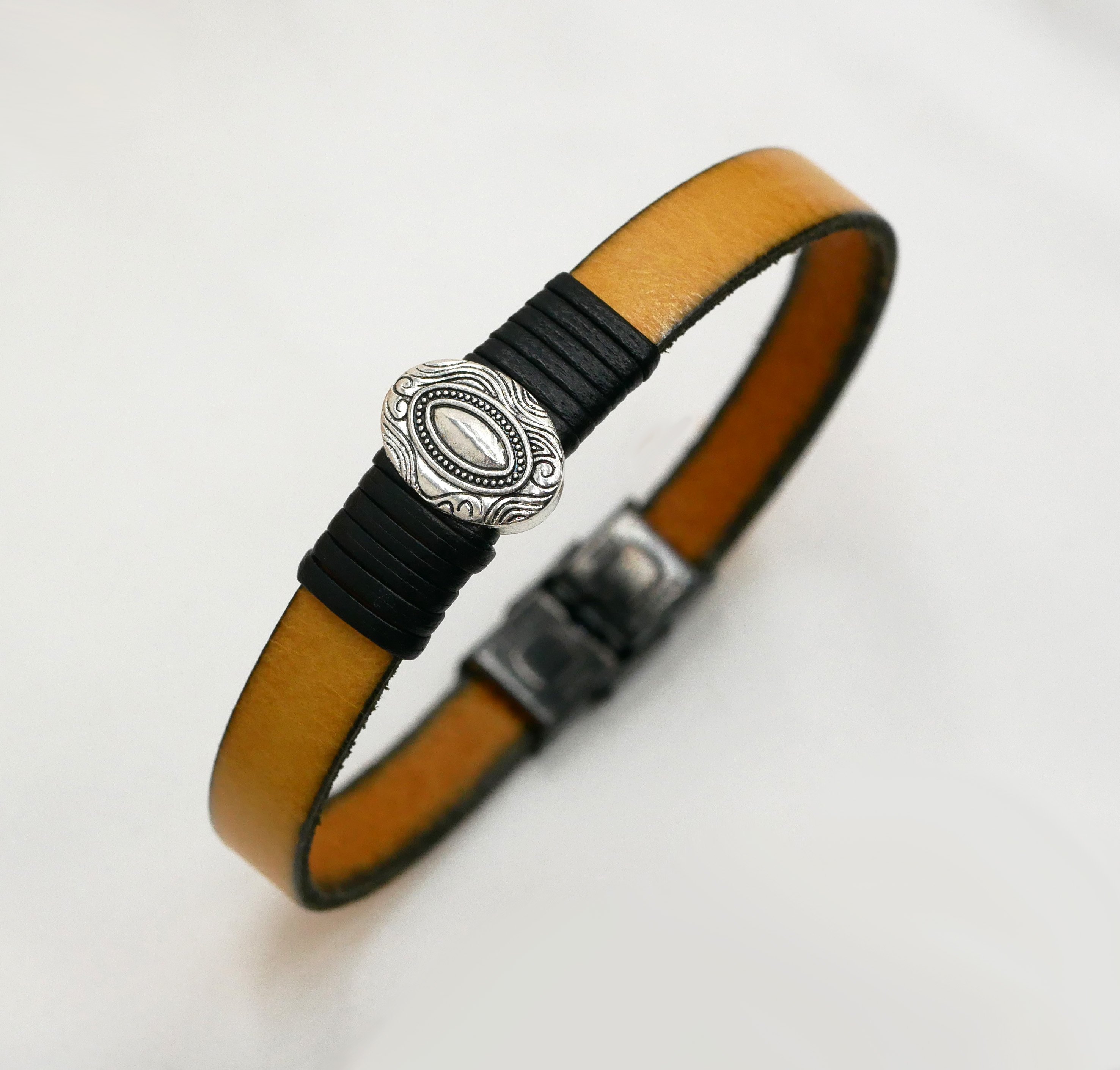 L&aelig;derrem, der kan tilpasses, med centralt ovalt ornament indrammet af fint l&aelig;der 