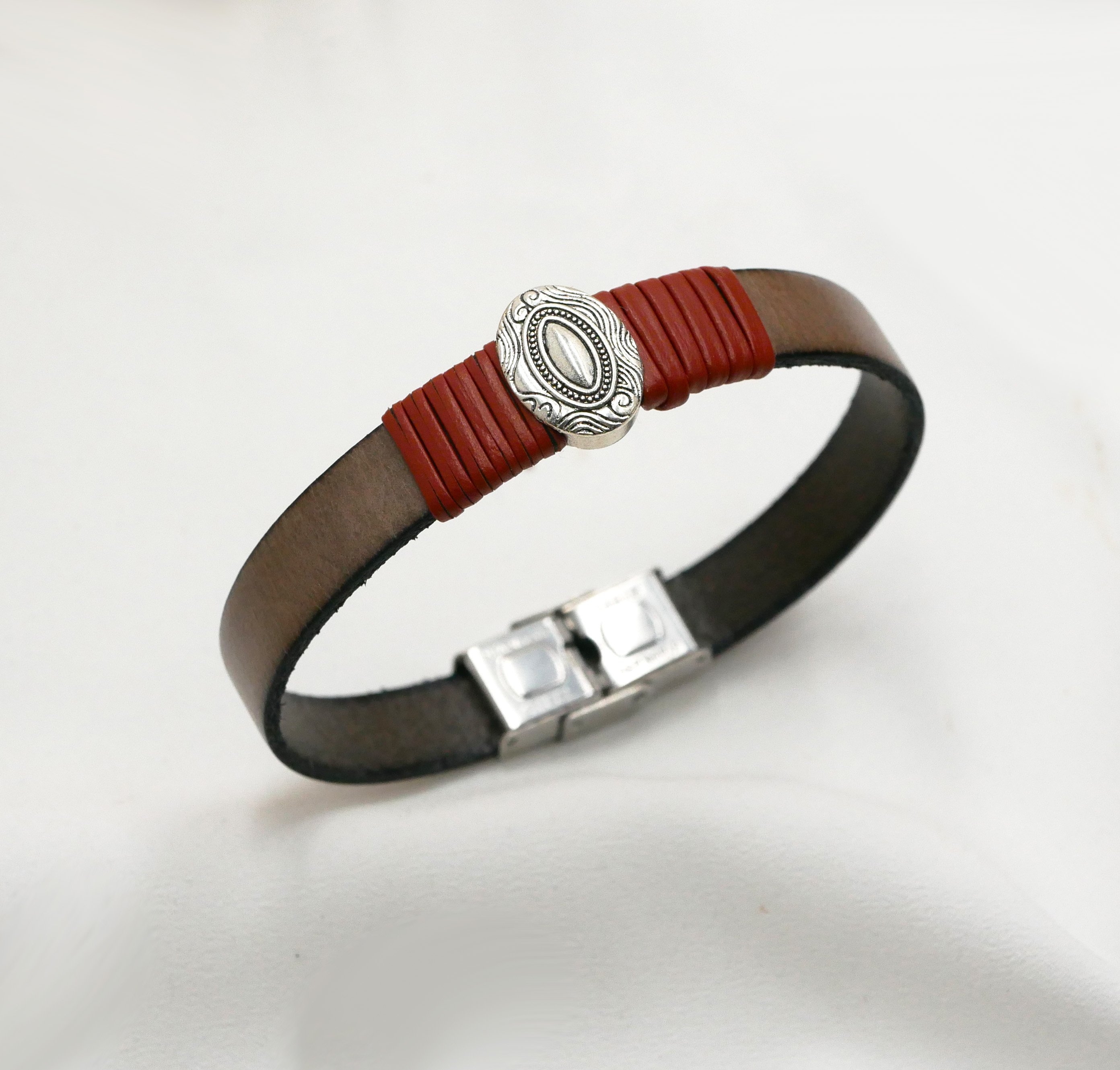 L&aelig;derrem, der kan tilpasses, med centralt ovalt ornament indrammet af fint l&aelig;der 