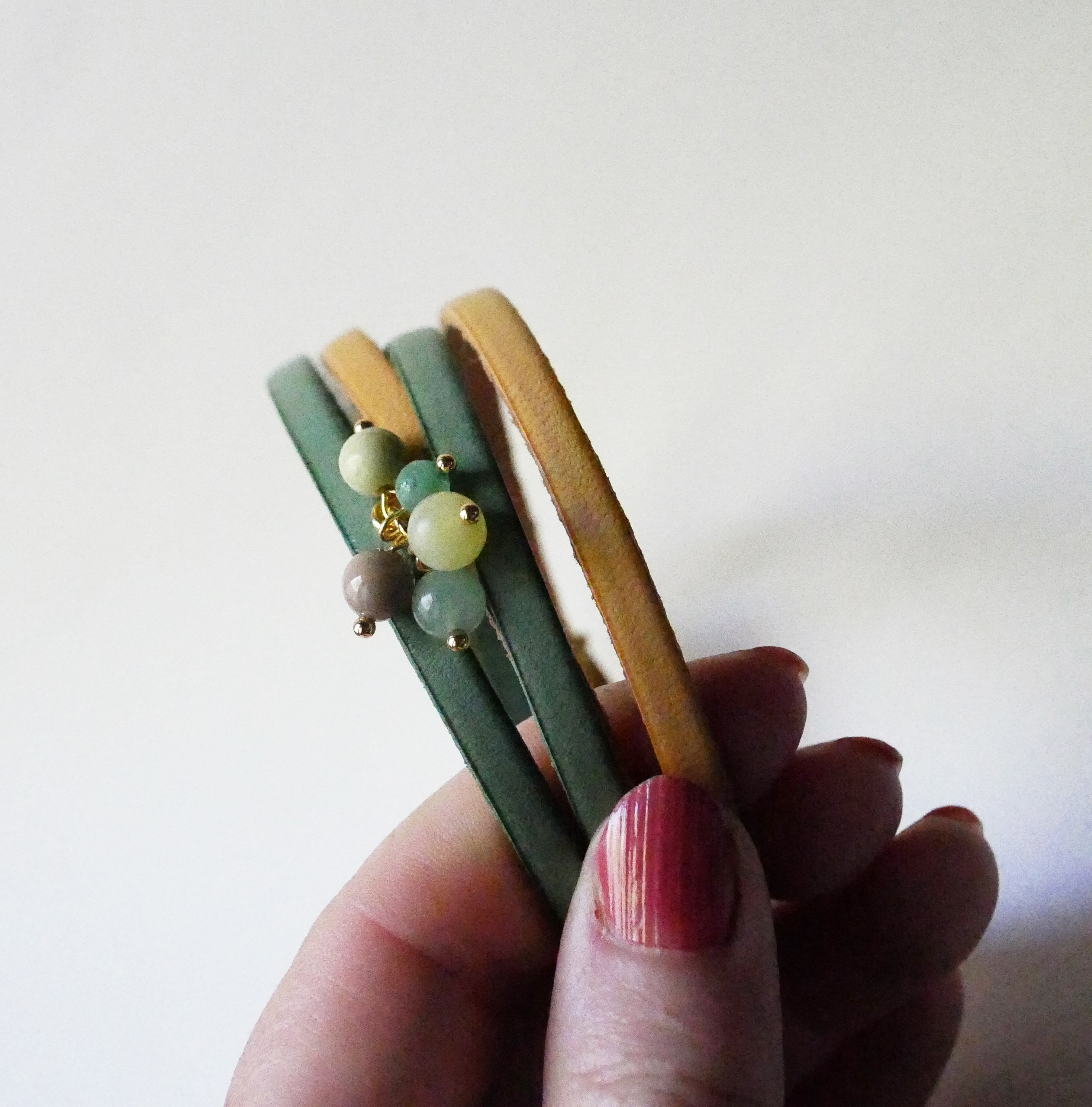 Dobbelt l&aelig;derarmb&aring;nd dekoreret med bl&oslash;de gr&oslash;nne perler og guldl&aring;s