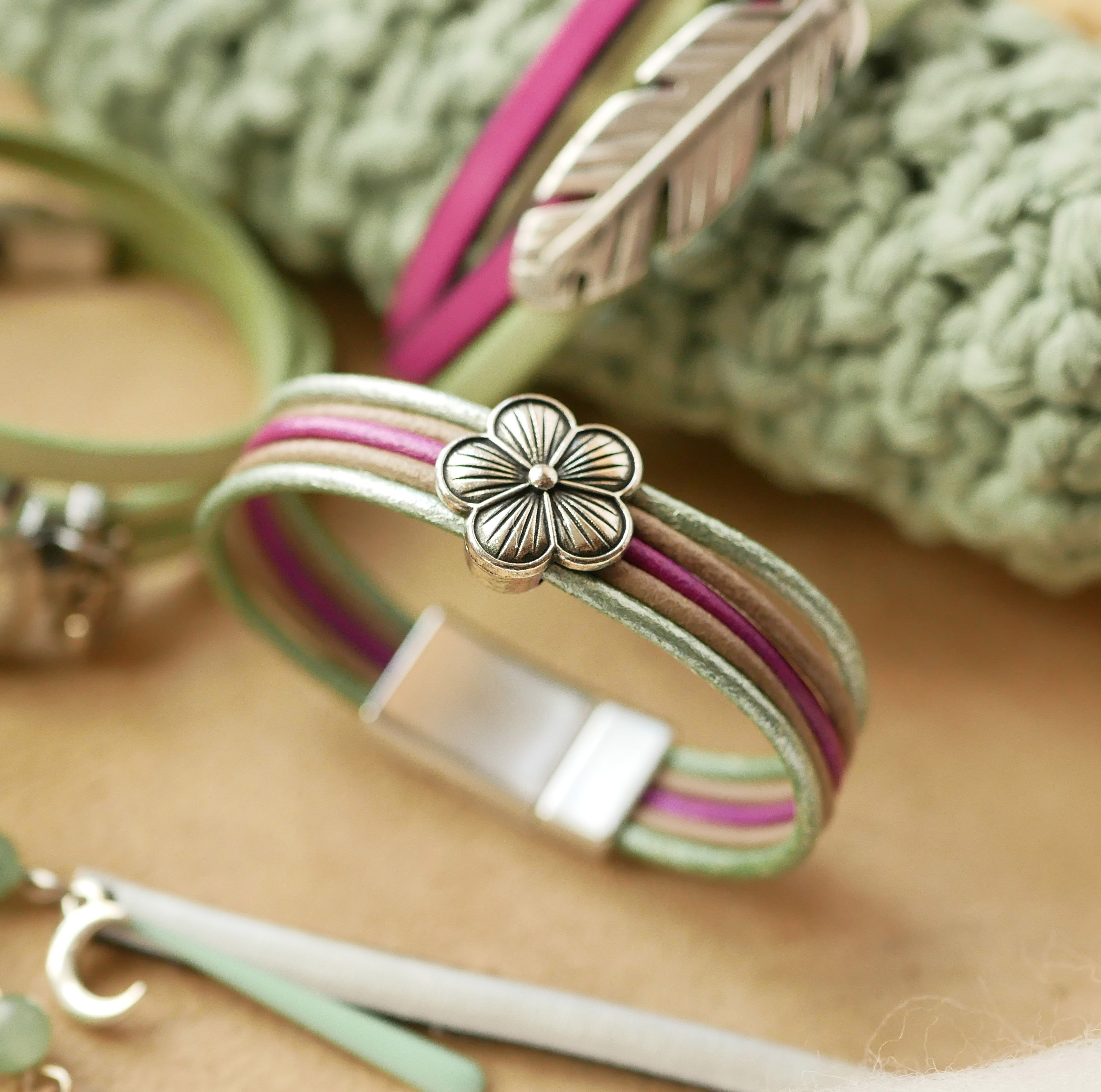 Damearmbånd med pastelfarvet læder og blomsterdesign i sølv