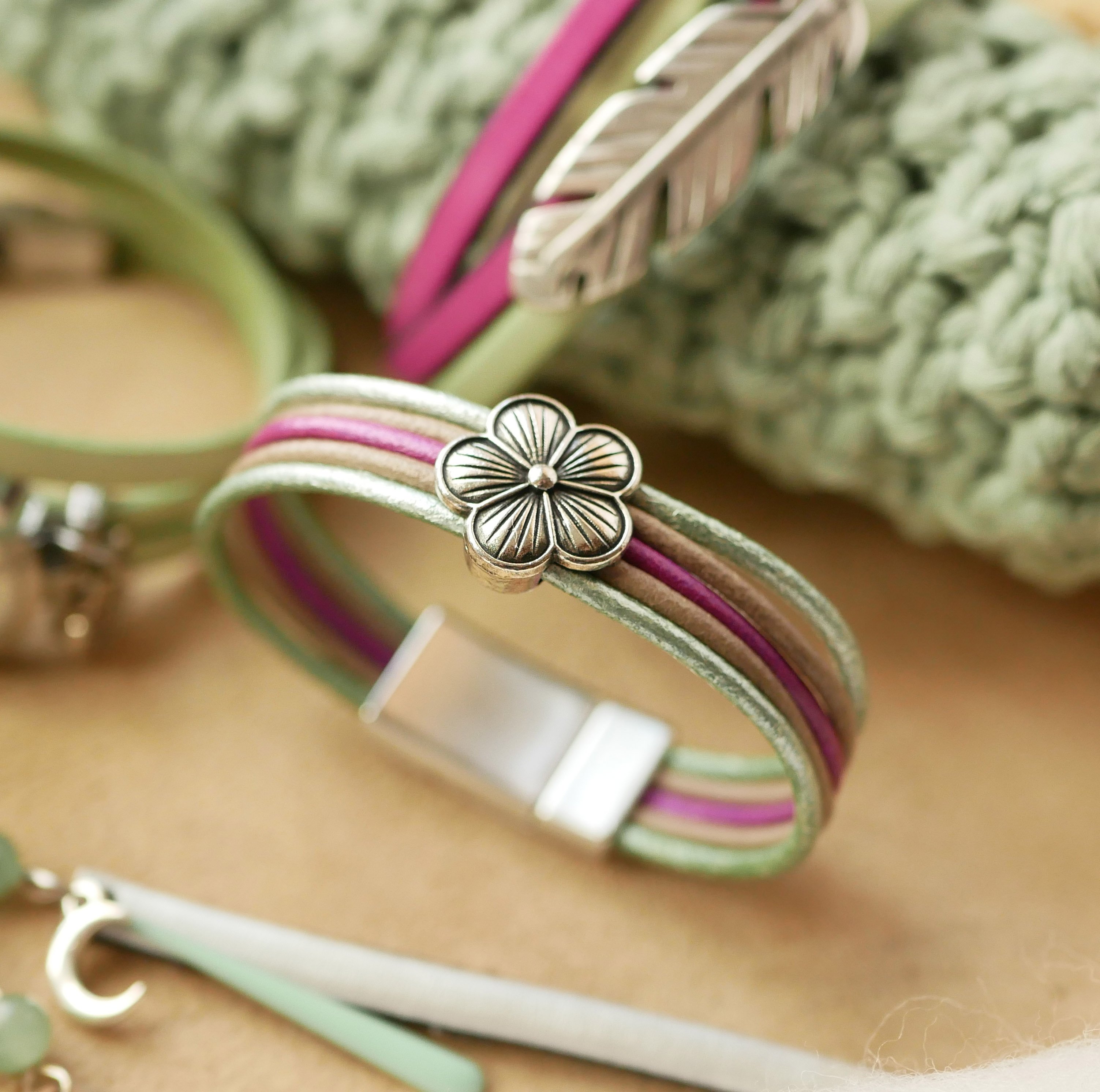Damearmbånd med pastelfarvet læder og blomsterdesign i sølv