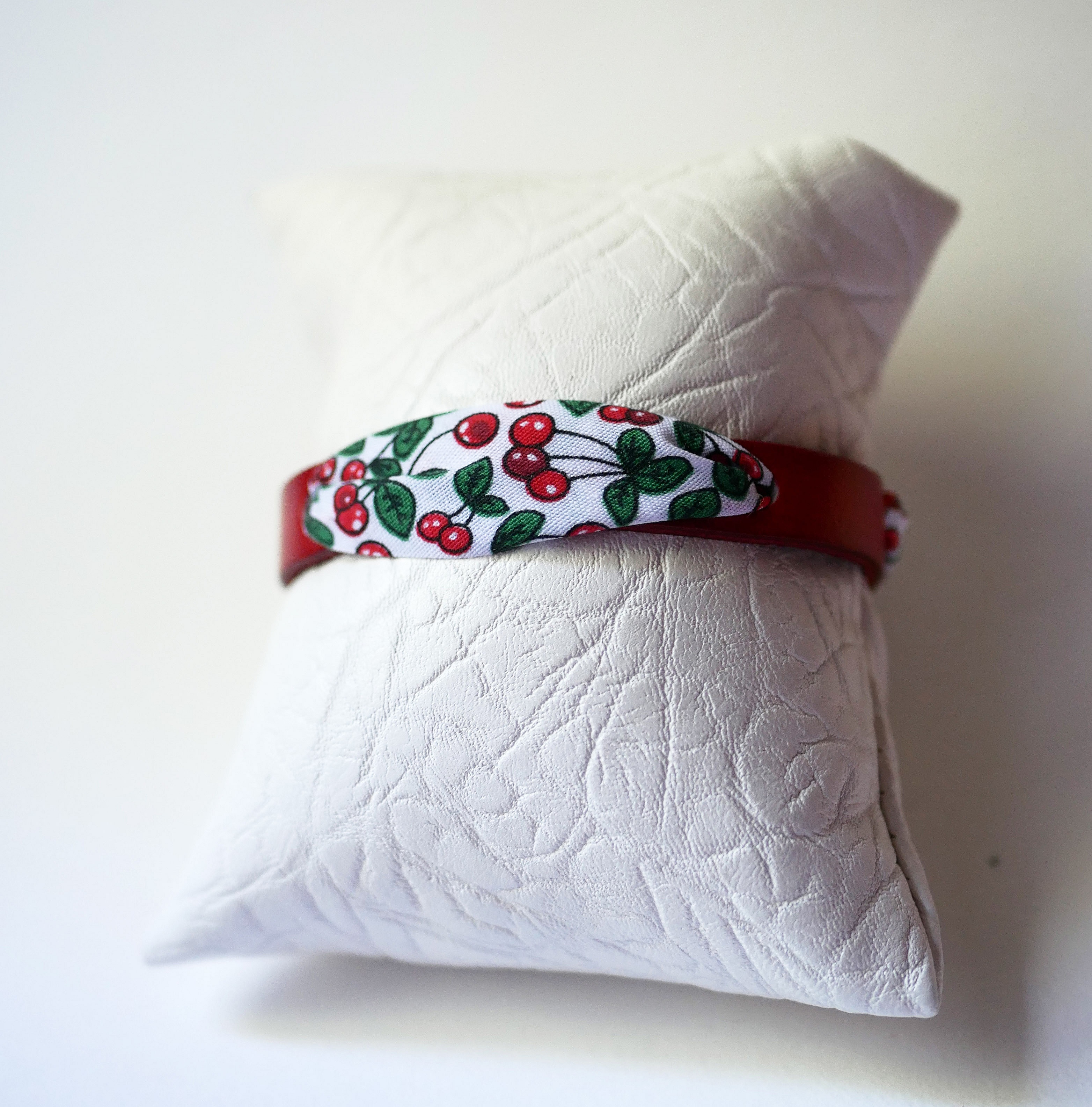 Flor&acirc;me-armb&aring;nd med b&aring;nd af kirseb&aelig;rfrugter p&aring; r&oslash;dt l&aelig;der