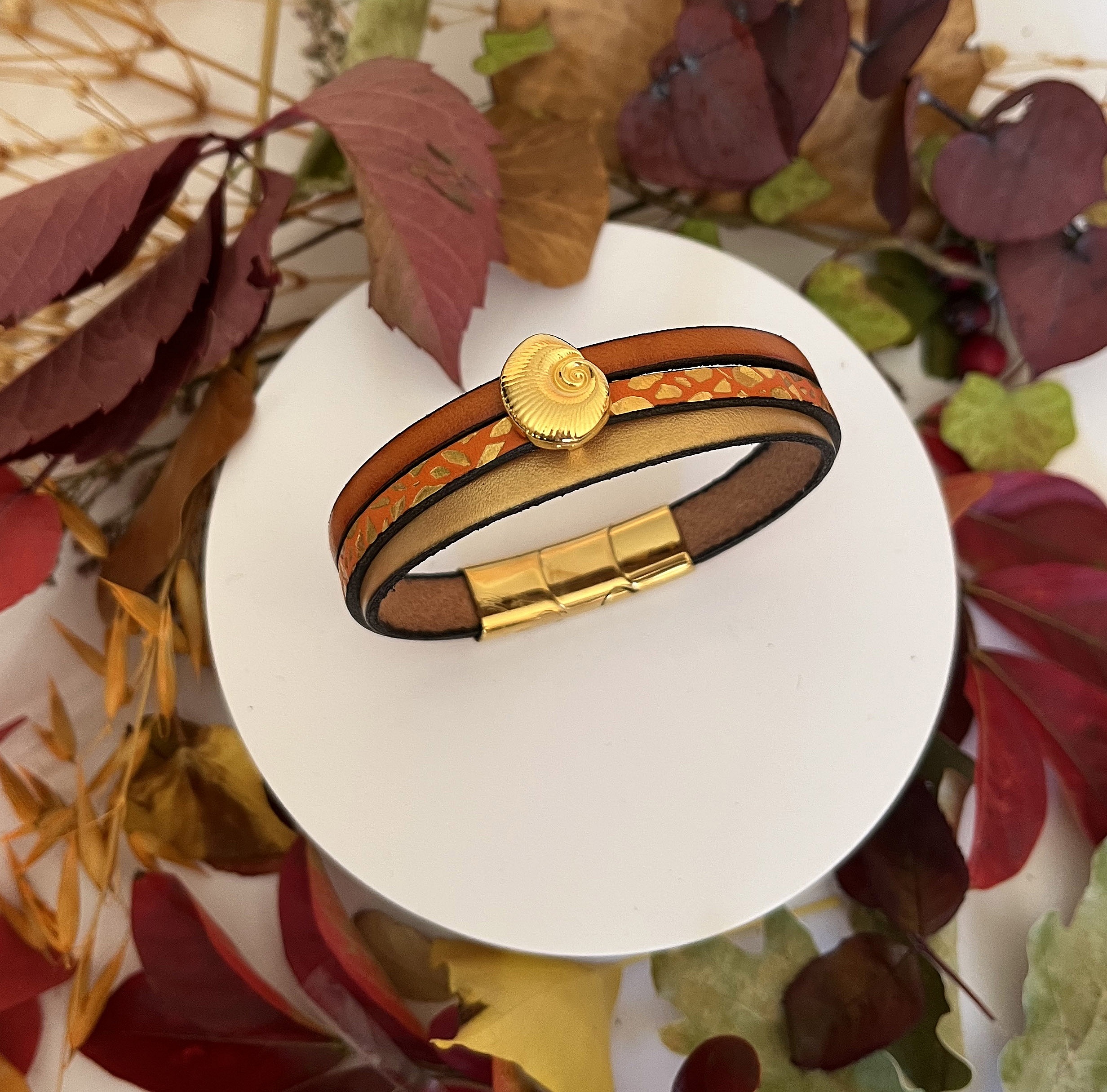 Manchetarmb&aring;nd i guld til kvinde Guld og orange skal