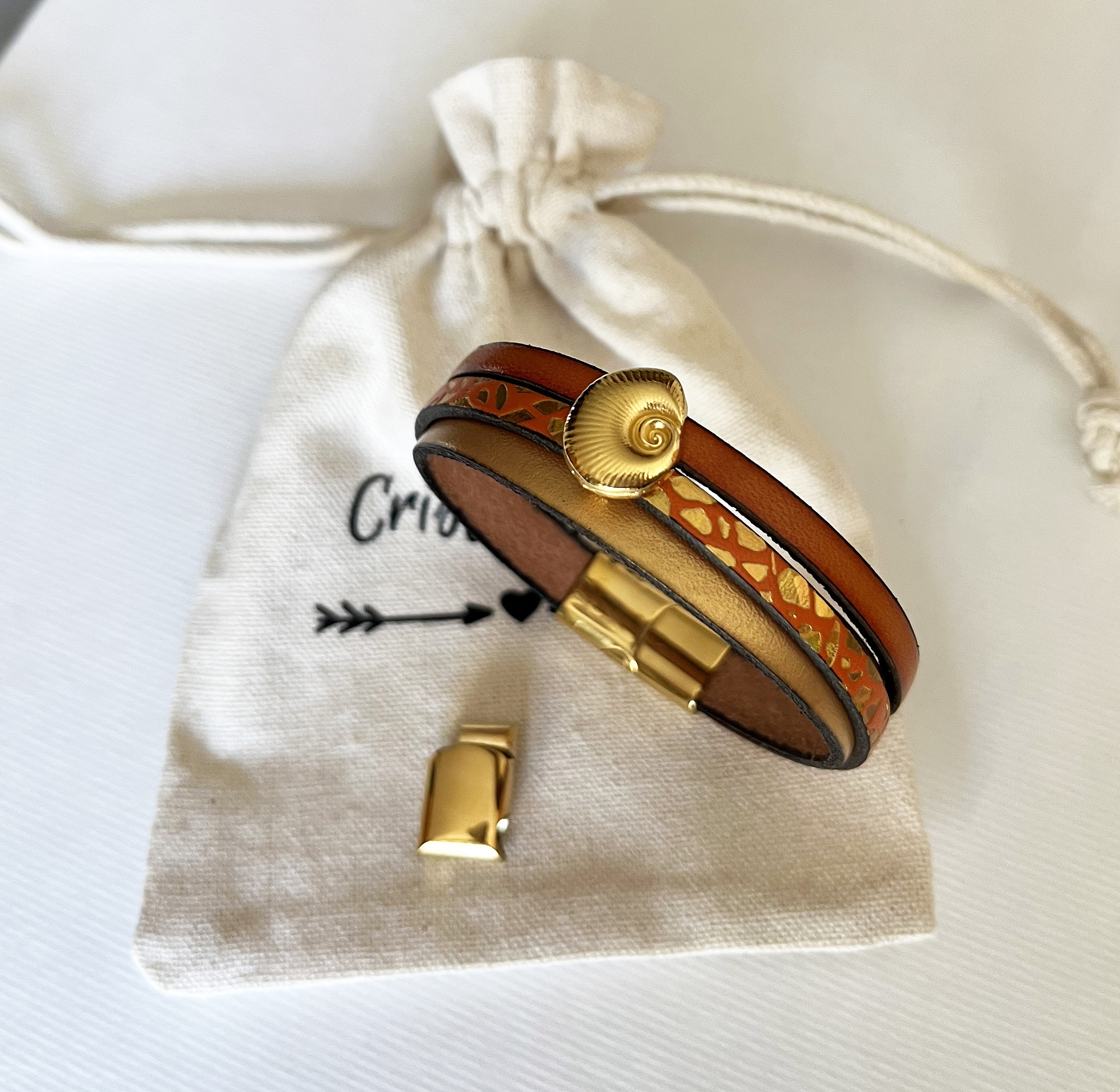 Manchetarmb&aring;nd i guld til kvinde Guld og orange skal