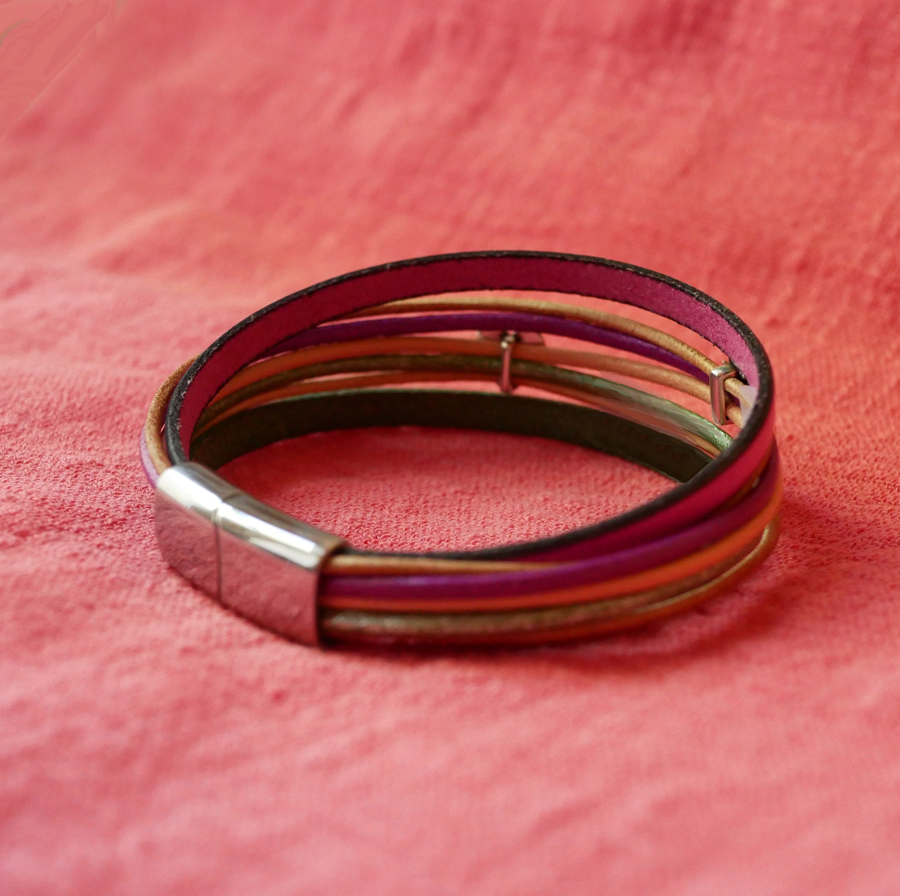 Manchetarmb&aring;nd i fuchsiafarvet l&aelig;der med 2 s&oslash;lvfarvede sl&oslash;jfer