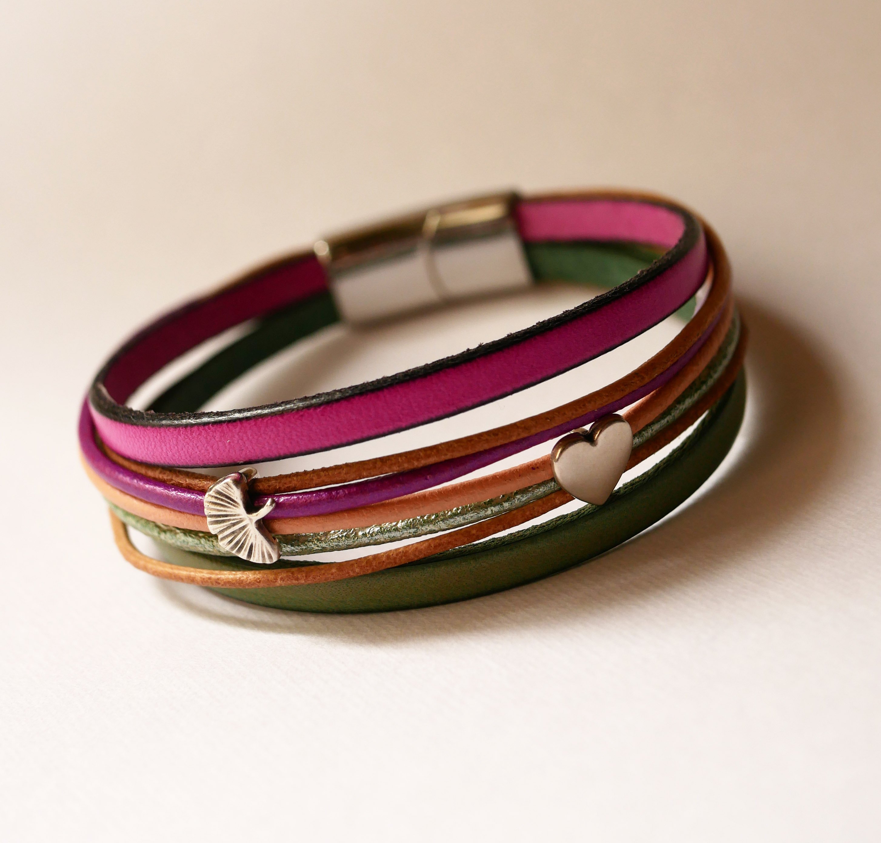 Manchetarmb&aring;nd i fuchsiafarvet l&aelig;der med 2 s&oslash;lvfarvede sl&oslash;jfer