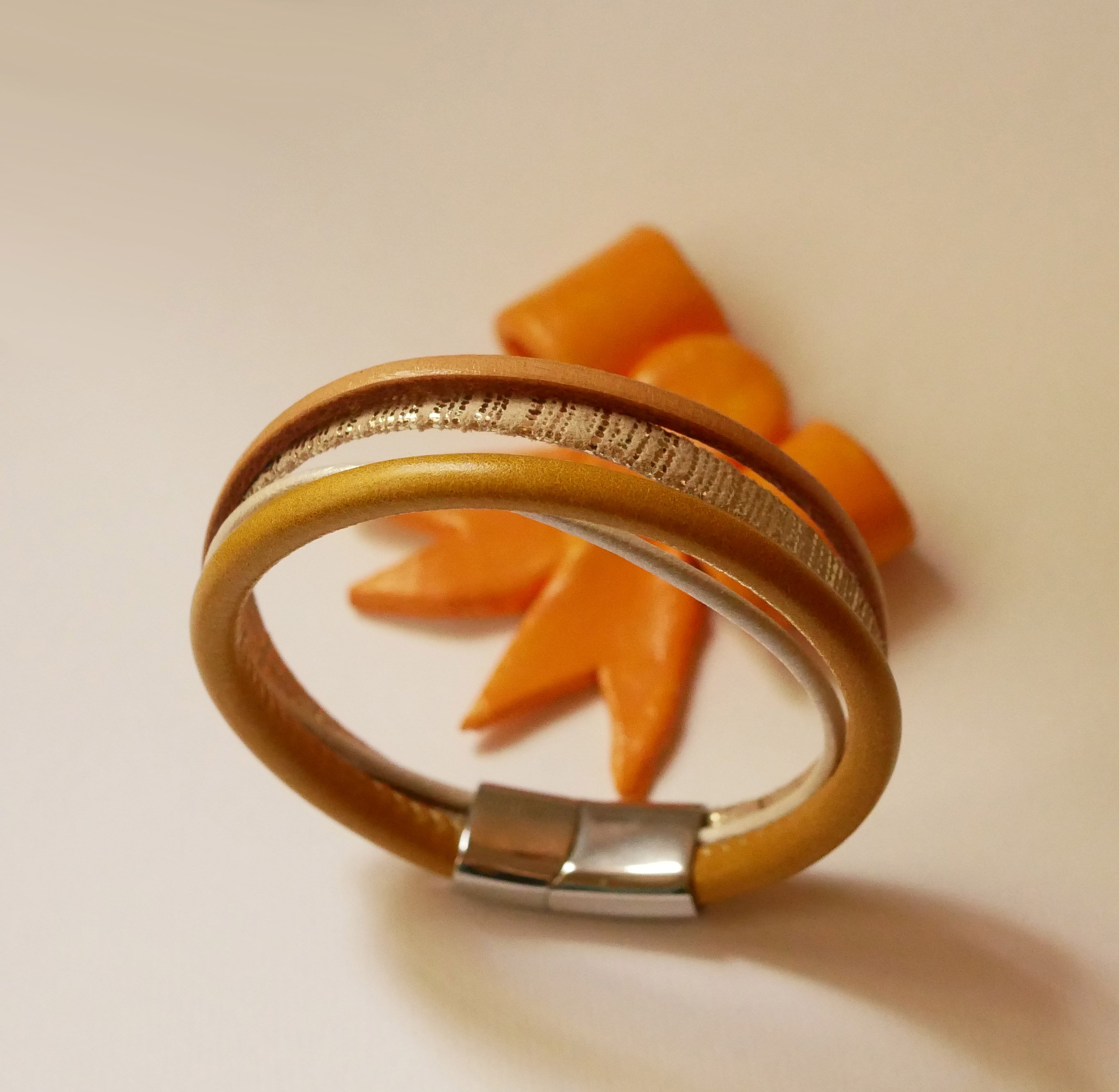 Manchetarmb&aring;nd i l&aelig;der i beige og guld