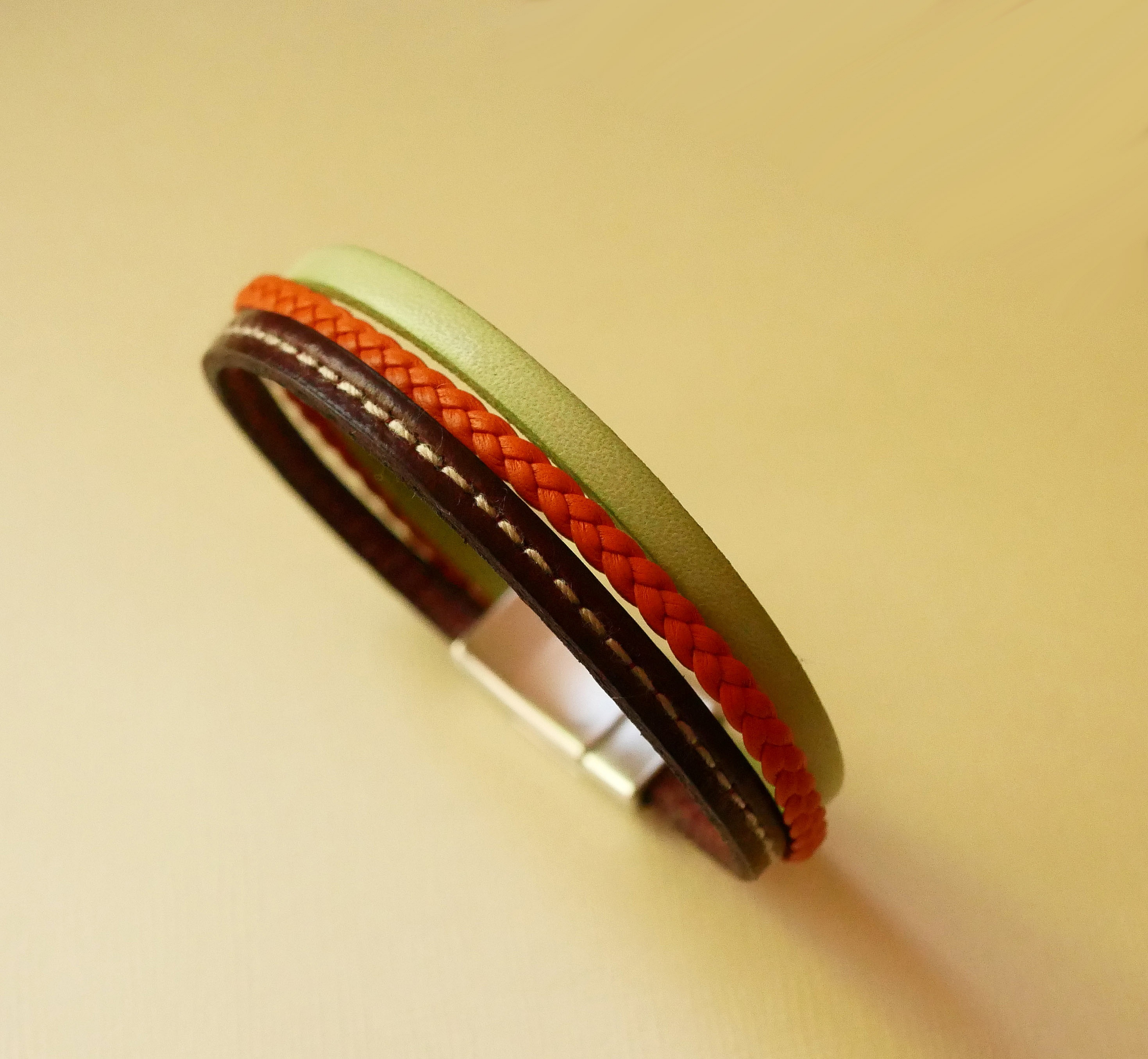 Manchetarmb&aring;nd i multi-l&aelig;der med mandel, orange fletning og bordeauxfarvede syninger