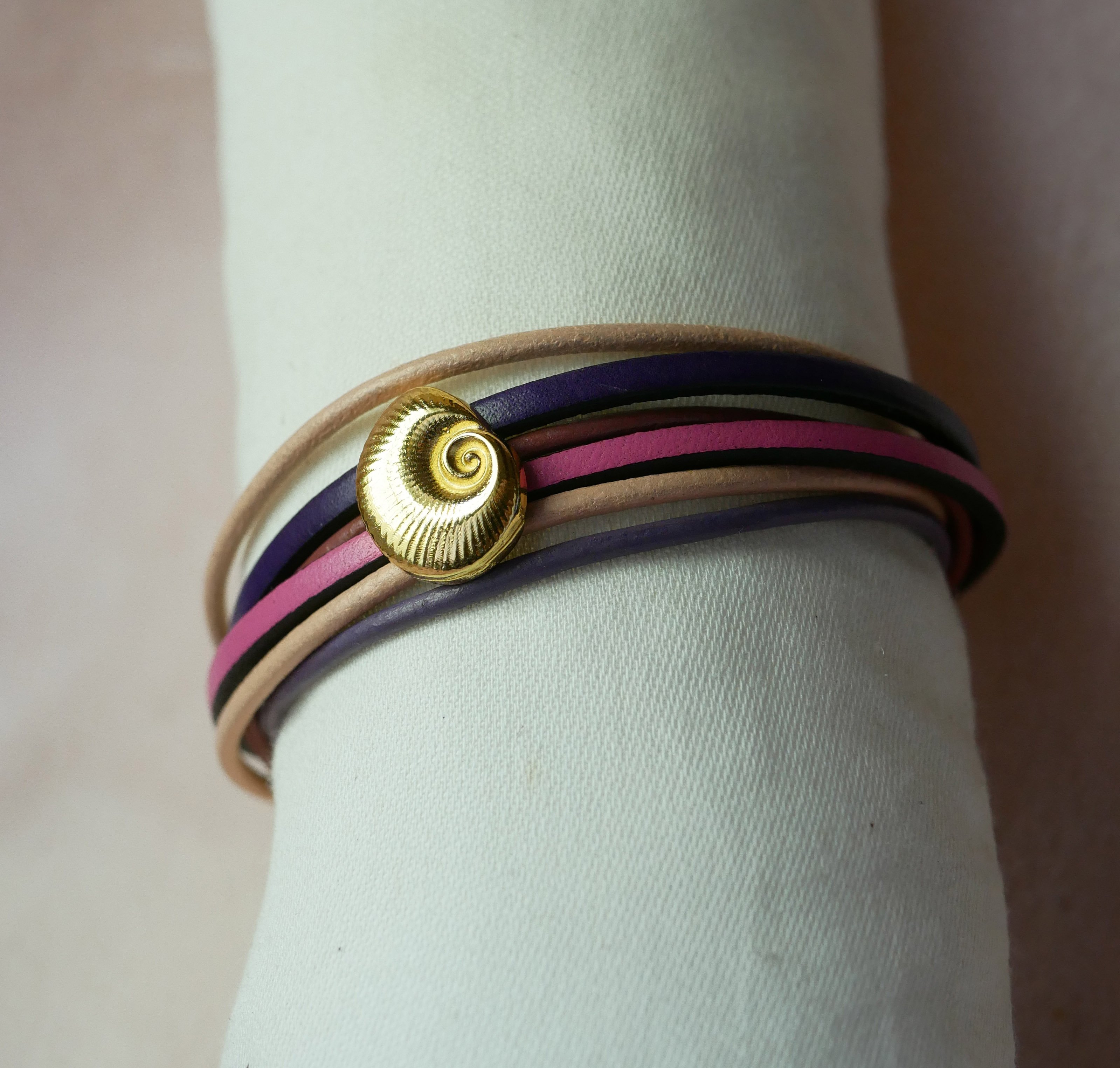 Flerleddet armb&aring;nd i ferskenfarvet og mauvefarvet l&aelig;der med skaldekoration i guld
