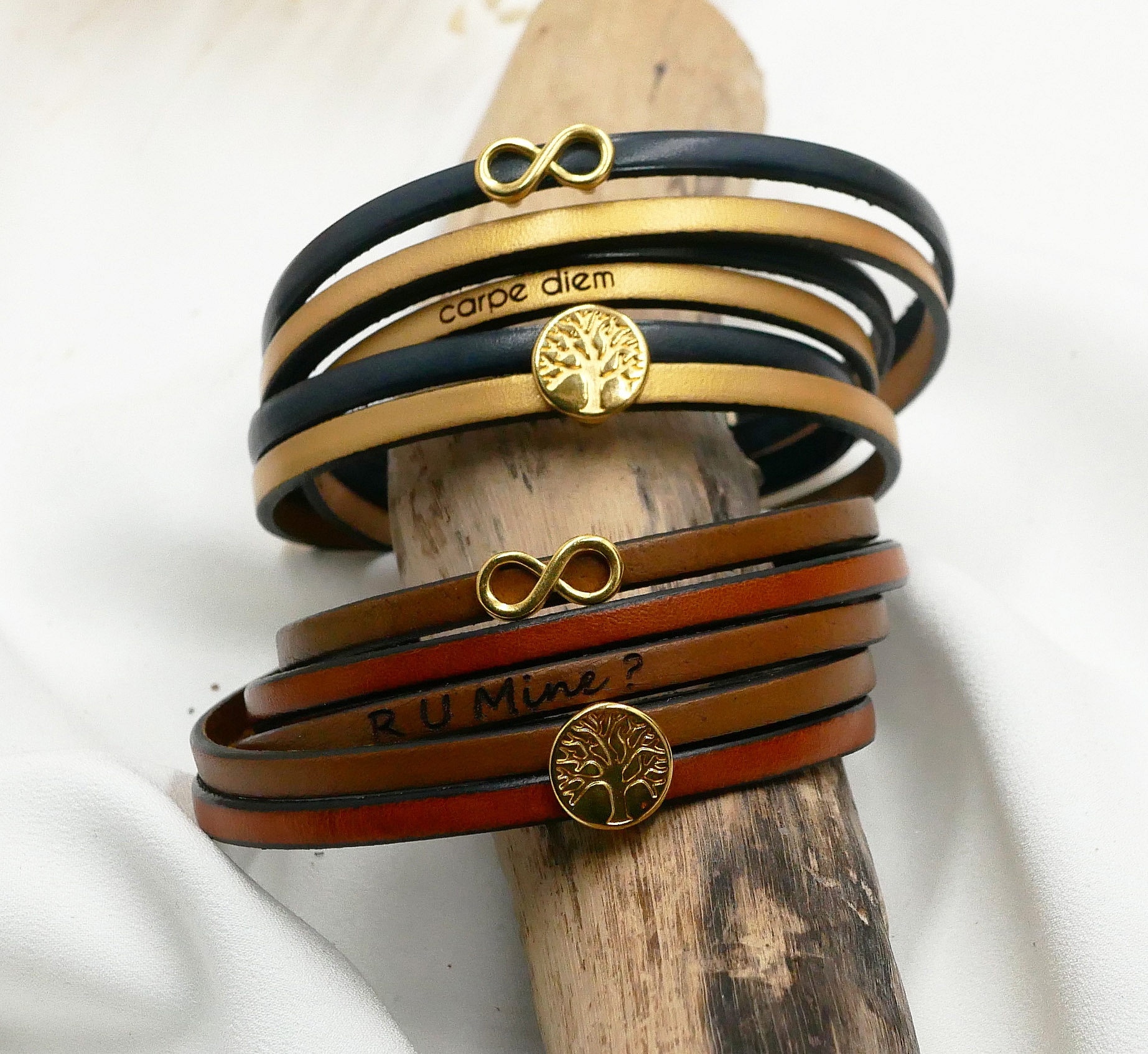 Bracelets en cuir personnalisés avec symboles dorés et gravures.