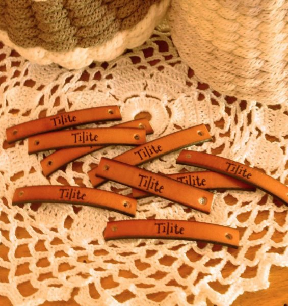 Skr&aelig;ddersyet l&aelig;deretiket med indgraveret besked