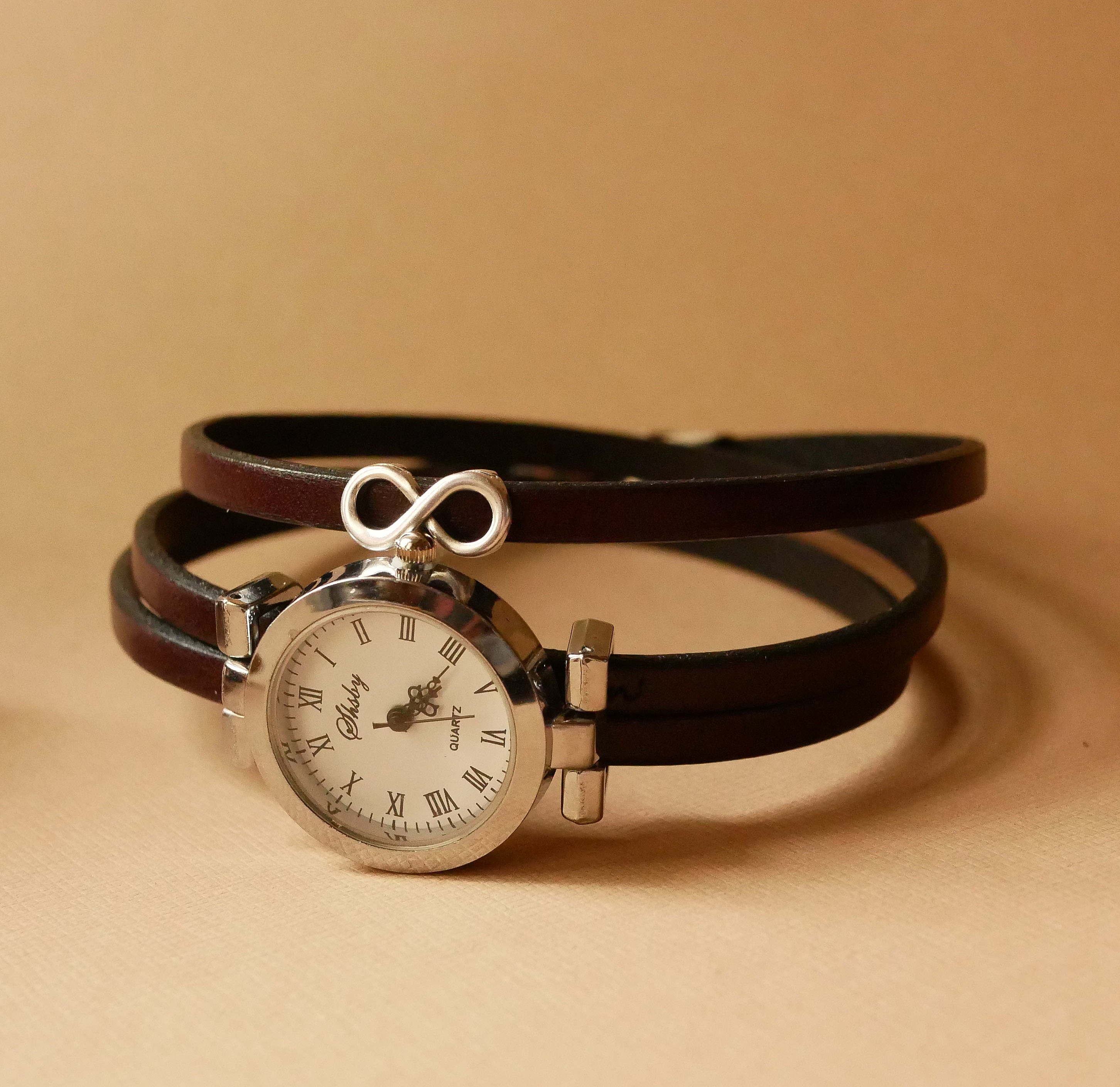 Montre femme bracelet cuir trois tours avec cadran argenté.