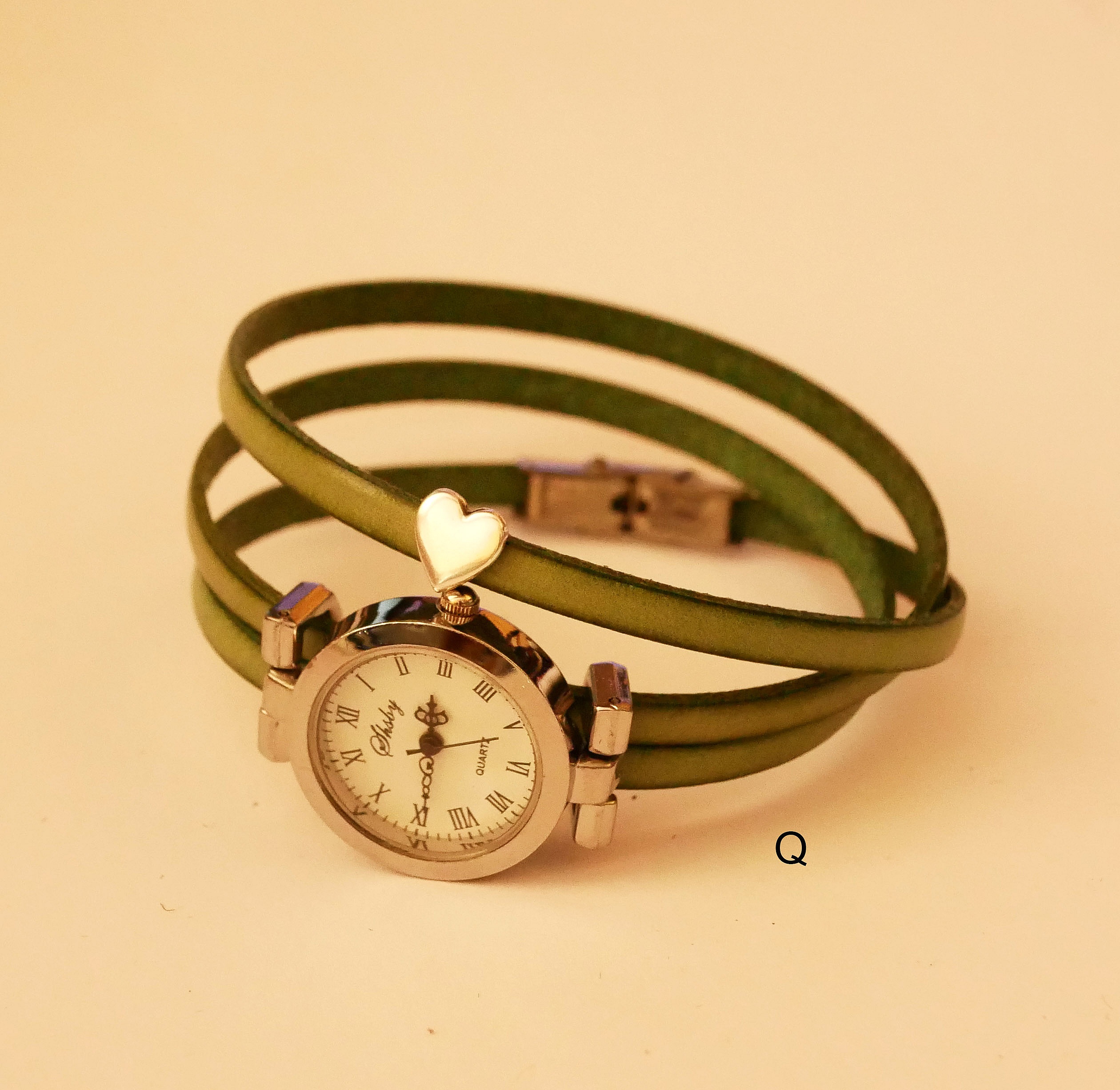 Montre bracelet cuir trois tours vert avec cadran argenté.