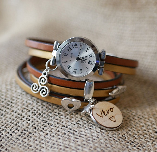 Montre bracelet en cuir personnalisable avec breloques gravées.