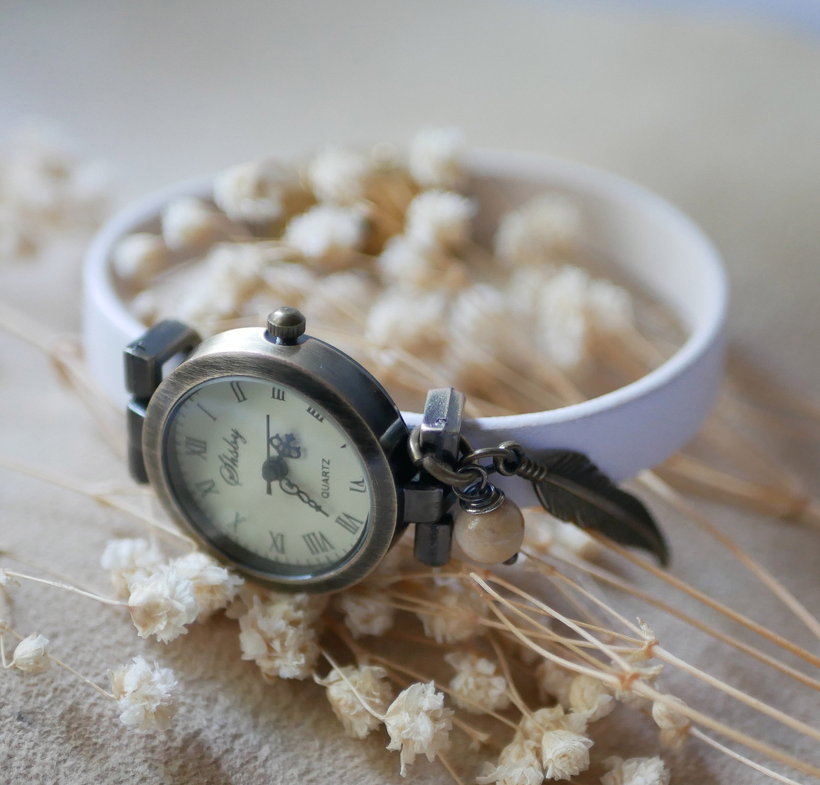 Montre à cadran bronze et bracelet en cuir blanc personnalisable.