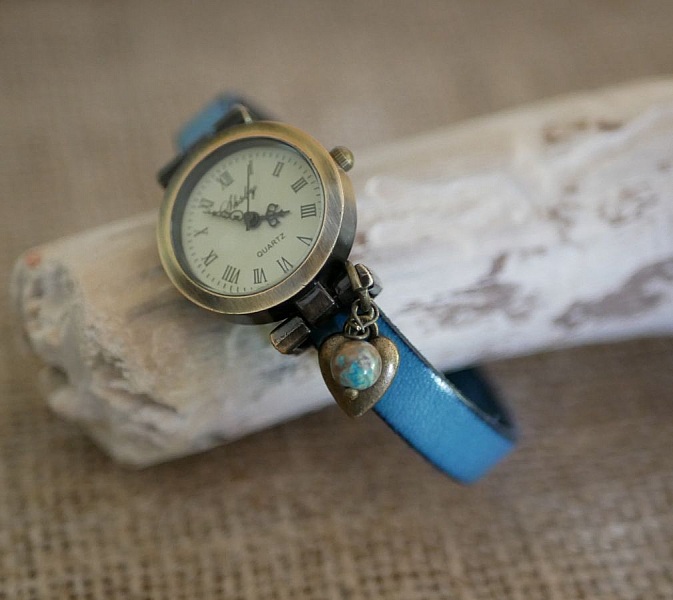 Montre à cadran bronze et bracelet en cuir bleu personnalisable.