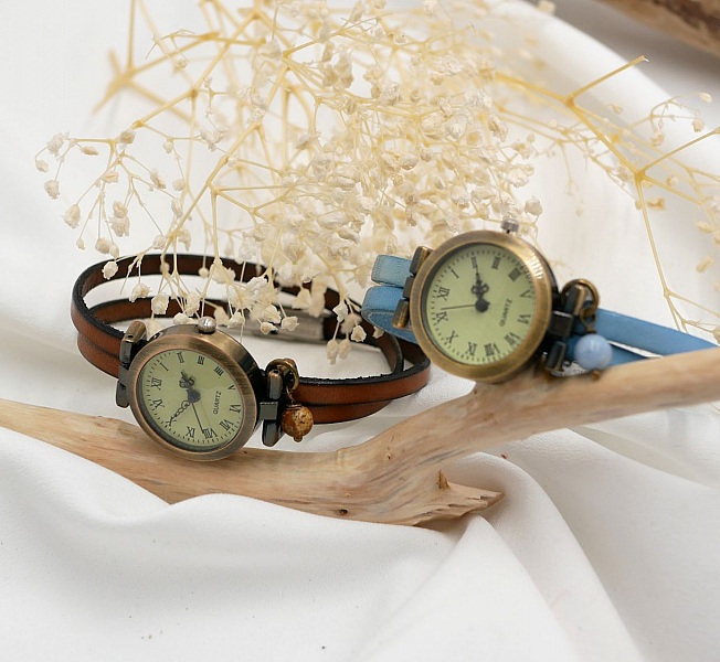 Montres bracelet personnalisables en cuir sur fond floral.