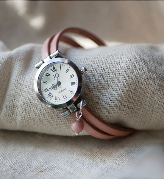 Montre bracelet personnalisable en cuir rose avec breloque.