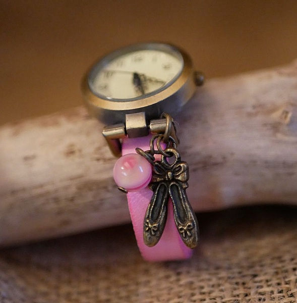 Montre fille avec bracelet cuir rose et breloque danse bronze.